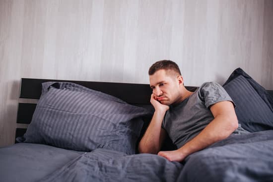 mężczyzna w łóżku martwi się niskim poziomem testosteronu